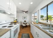 Thumbnail 11 of 41 - a kitchen with white cabinets and a sink and a window