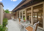 Thumbnail 14 of 57 - a patio with a table and chairs and a pool in the background