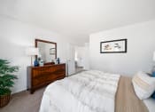 Thumbnail 16 of 41 - a bedroom with a bed and a dresser with a mirror