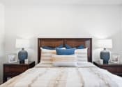 Thumbnail 13 of 41 - a bedroom with a bed with blue pillows and two lamps