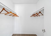 Thumbnail 15 of 41 - a closet with clothes hangers and a white wall