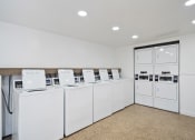 Thumbnail 34 of 57 - a laundry room with white washers and dryers