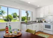 Thumbnail 9 of 41 - a kitchen with white cabinets and a wooden table