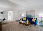 Thumbnail 4 of 24 - a living room with a blue couch and a coffee table