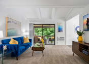 Thumbnail 5 of 24 - a living room with a blue couch and a coffee table