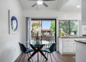 Thumbnail 8 of 24 - a dining room with a glass table and chairs and a window
