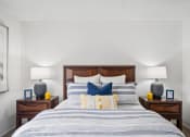 Thumbnail 16 of 24 - a bedroom with a bed with blue and white pillows and a wooden headboard