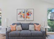 Thumbnail 29 of 41 - a living room with a couch and two paintings on the wall