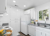 Thumbnail 9 of 68 - a kitchen with white cabinets and a sink and a refrigerator
