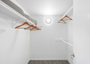 Thumbnail 15 of 68 - an empty closet with clothes hangers in a white room