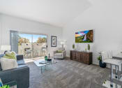 Thumbnail 26 of 68 - a living room with white walls and a sliding glass door to a balcony