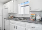 Thumbnail 29 of 68 - a kitchen with white cabinets and granite counter top and a sink