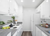 Thumbnail 28 of 68 - a white kitchen with white appliances and granite counter tops