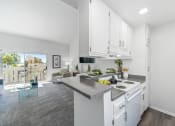 Thumbnail 30 of 68 - an open kitchen and living room with white cabinets and granite counter tops