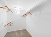 Thumbnail 40 of 68 - the interior of a white closet with white walls and orange hooks