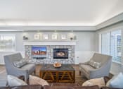 Thumbnail 67 of 68 - a living room with a stone fireplace and chairs and a table