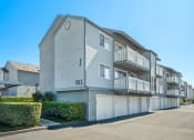 Thumbnail 57 of 68 - a street view of an apartment building with garages and balconies
