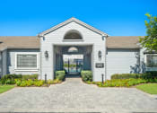 Thumbnail 59 of 68 - the front of a white house with a driveway and a gate