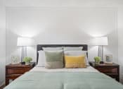 Thumbnail 15 of 32 - a bedroom with white walls and a bed with green and yellow pillows