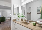 Thumbnail 18 of 32 - a bathroom with a sink and mirrors and a living room