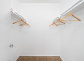 Thumbnail 17 of 32 - a white room with two hanging racks on the wall