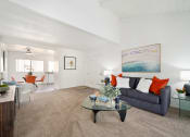 Thumbnail 4 of 34 - a living room with a blue couch and a glass coffee table