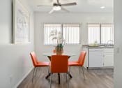 Thumbnail 12 of 34 - a dining area with a table and chairs and a kitchen in the background