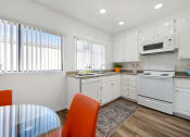 Thumbnail 10 of 34 - a kitchen with white cabinets and a white stove top oven