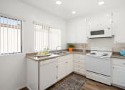 Thumbnail 11 of 34 - a kitchen with white cabinets and white appliances