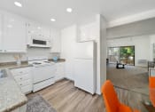 Thumbnail 9 of 34 - a kitchen and living room with white appliances and white cabinets