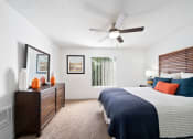 Thumbnail 23 of 34 - a bedroom with a large bed and a ceiling fan