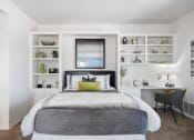 Thumbnail 49 of 61 - a bedroom with a bed and a desk with a chair