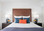 Thumbnail 24 of 34 - a bedroom with a bed with blue and orange pillows
