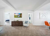 Thumbnail 7 of 34 - a living room with white walls and a brown carpet