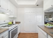 Thumbnail 51 of 61 - a kitchen with white cabinetry and a white stove top oven