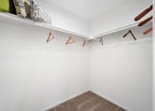 Thumbnail 53 of 61 - a walk in closet with white walls and a white shelf
