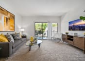 Thumbnail 31 of 61 - a living room with a couch chair and coffee table with a sliding glass door leading to a