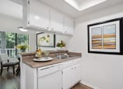 Thumbnail 34 of 61 - a kitchen with white cabinetry and a white dishwasher