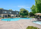 Thumbnail 59 of 61 - a swimming pool with umbrellas and a building in the background