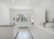 Thumbnail 28 of 61 - a kitchen with white cabinetry and a large window