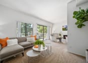 Thumbnail 2 of 61 - a living room with a couch coffee table and sliding glass doors to a balcony