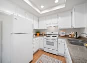 Thumbnail 7 of 61 - a kitchen with white cabinetry and white appliances