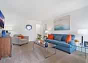 Thumbnail 8 of 19 - a living room with a blue couch and a glass coffee table