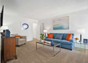 Thumbnail 4 of 19 - a living room with a blue couch and a coffee table
