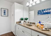 Thumbnail 12 of 41 - a bathroom with white cabinets and a sink and a mirror
