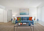 Thumbnail 2 of 19 - a living room with a blue couch and a coffee table