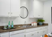 Thumbnail 19 of 19 - a kitchen with white cabinets and a sink and a counter top