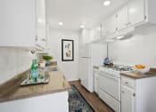 Thumbnail 11 of 19 - a white kitchen with white appliances and white cabinets