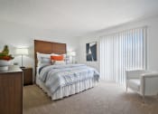 Thumbnail 13 of 19 - a bedroom with a bed and a white chair