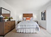 Thumbnail 14 of 19 - a bedroom with a bed and a dresser and a window